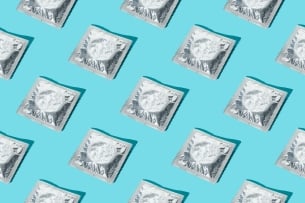 A pattern of silver condom wrappers on a blue background