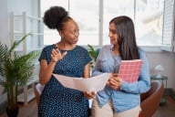 A photo of two women engaging in discussion in an office, suggesting the theme of mentorship and collaboration.