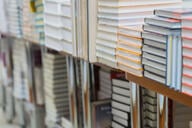 Stacks of books, textbooks or fiction in bookstore or in library