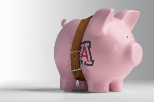 A photo illustration of a piggy bank with a belt tightened around it.