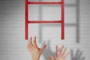 Hands grasp unsuccessfully at the bottom rung of a ladder