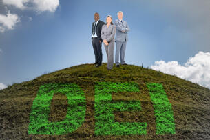 Three people in suits stand on a hill that reads "DEI."