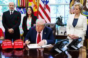 President Donald Trump signs an executive orders relating to higher education in the Oval Office.