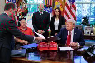 White House staff secretary Will Scharf hands U.S. President Donald Trump an executive order to sign in the Oval Office.