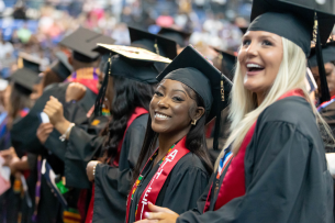 Two students smile during Columbus State University in Georgia's commencement ceremony